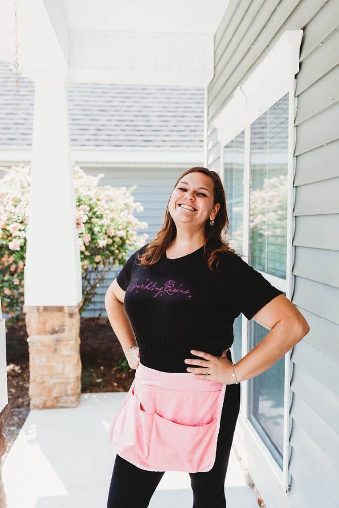 Smiling Sparkling Queens team member on a front porch